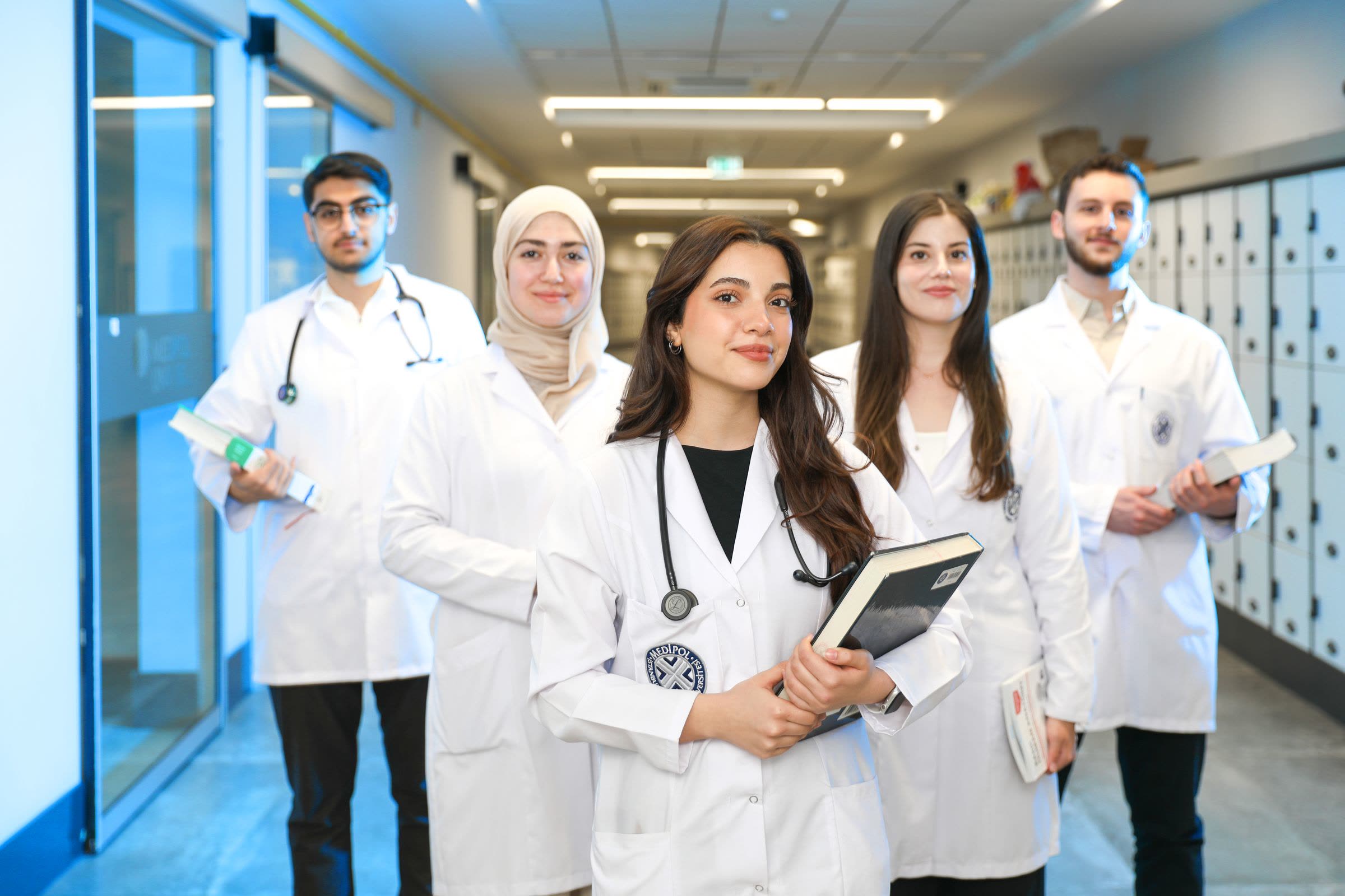 Medical students in white coats standing together in a university hospital corridor